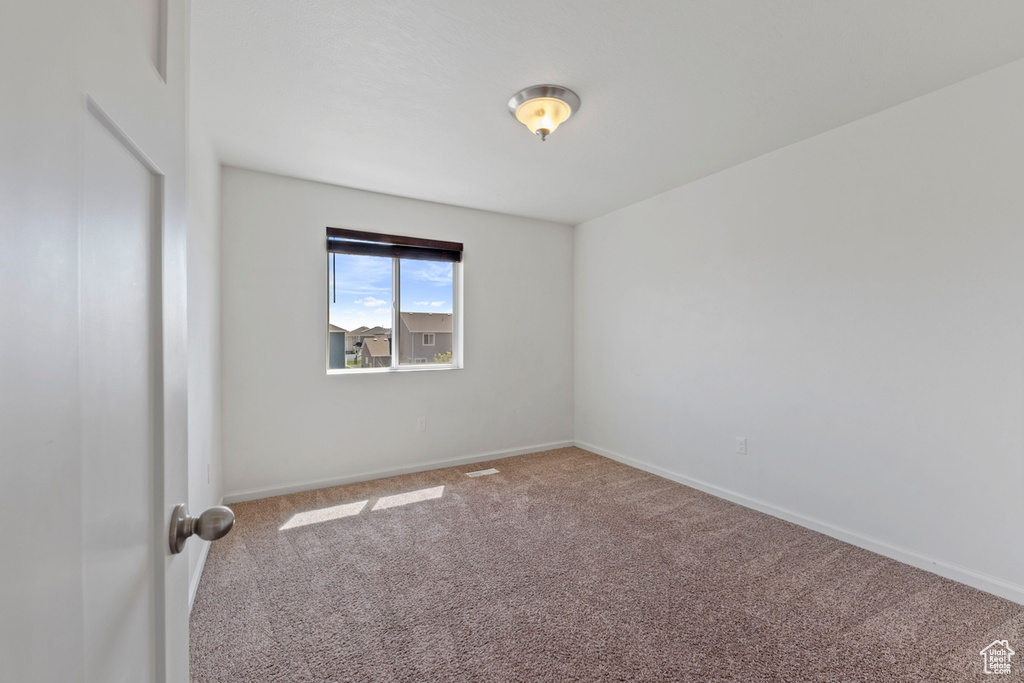 Carpeted spare room with baseboards