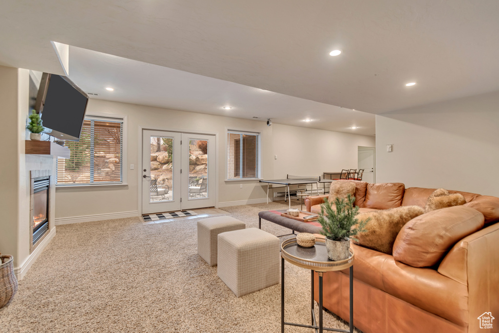 Carpeted living area with baseboards, recessed lighting, and a glass covered fireplace
