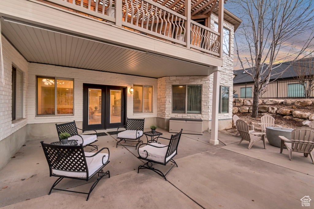 View of patio / terrace with a balcony, an outdoor fire pit, and french doors
