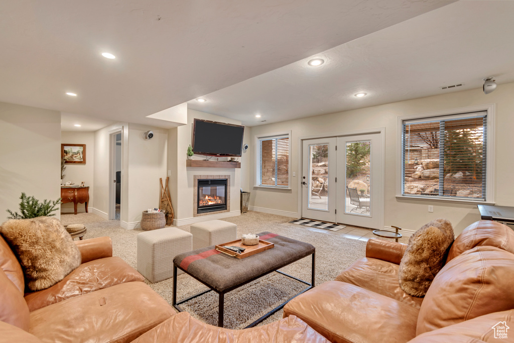 Living area featuring a tiled fireplace, visible vents, recessed lighting, and light colored carpet