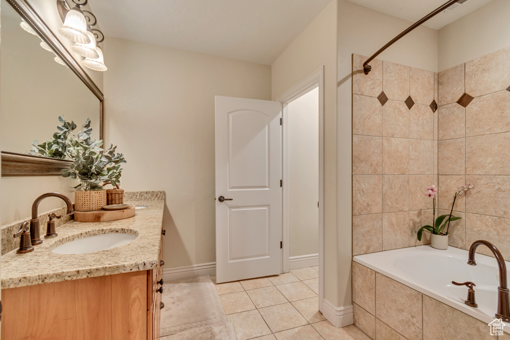 Bathroom featuring a shower, vanity, baseboards, tile patterned floors, and tiled tub