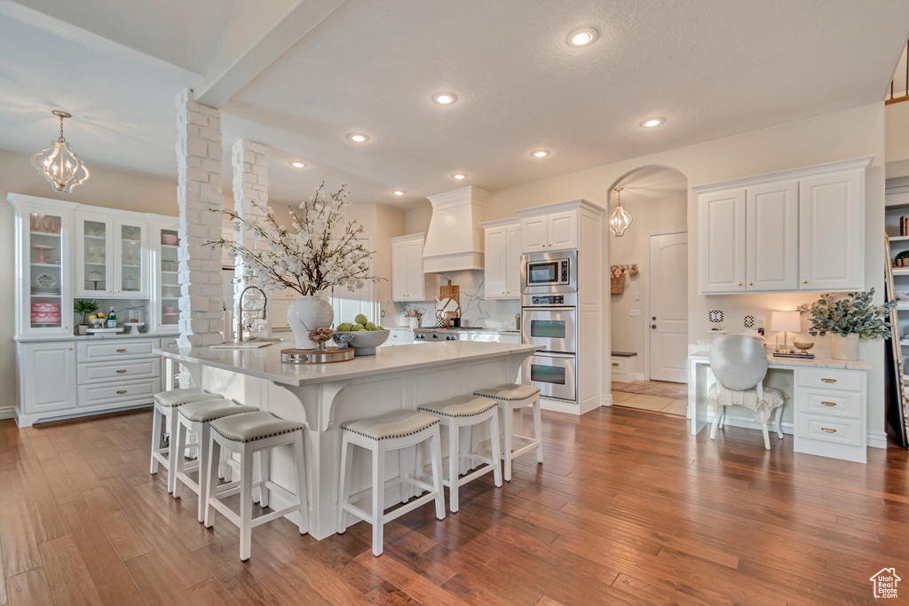 Kitchen with white cabinetry, light countertops, a sink, and a breakfast bar