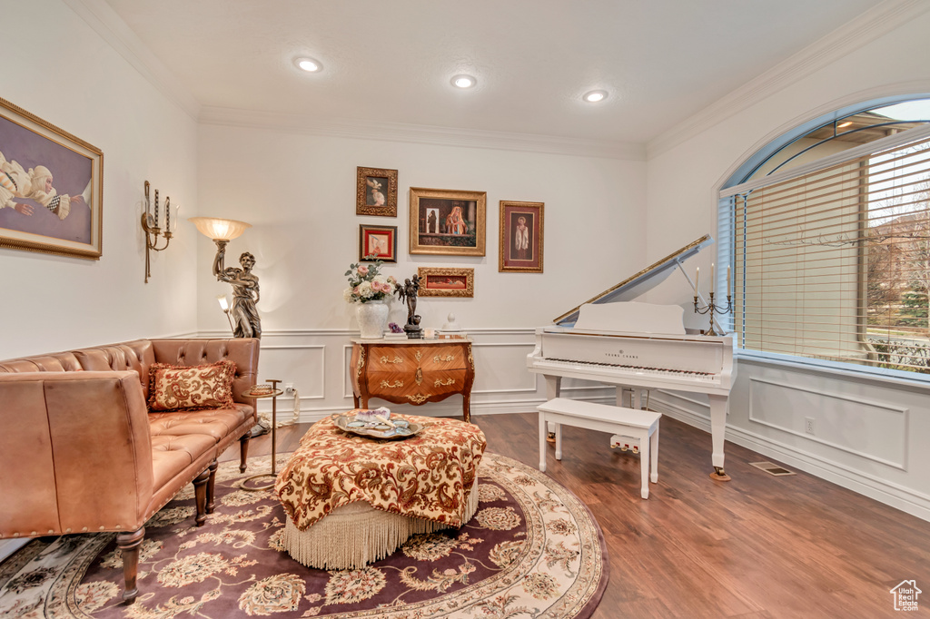 Sitting room with visible vents, crown molding, wood finished floors, and recessed lighting