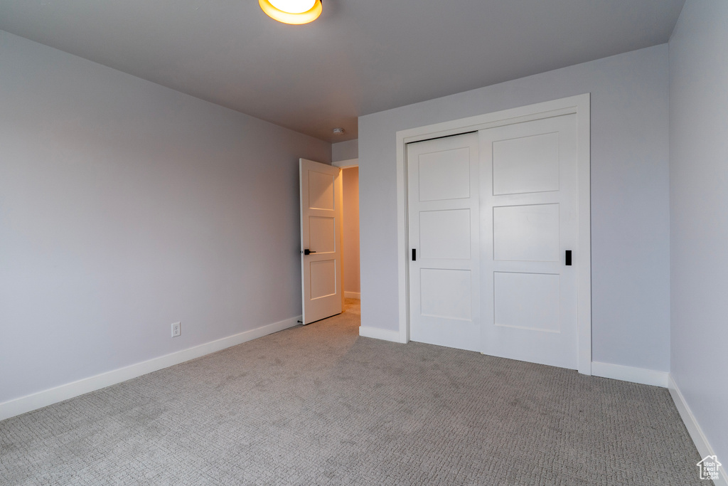 Unfurnished bedroom with a closet, baseboards, and carpet