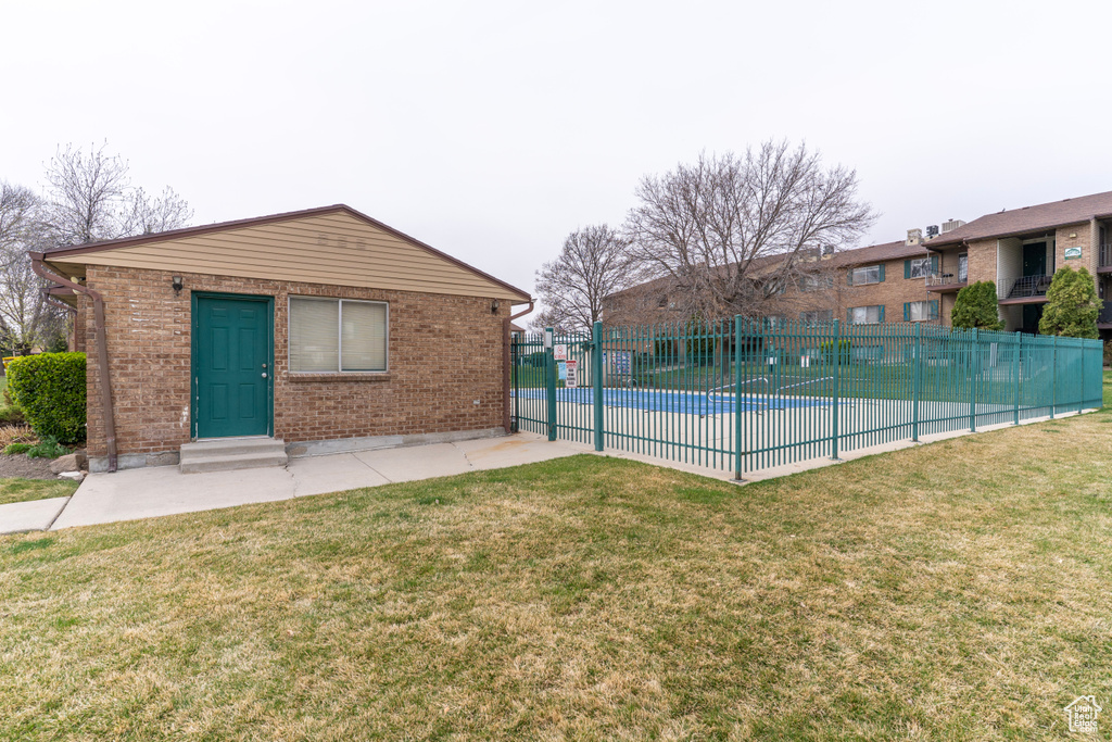 Pool featuring a lawn, fence, and a patio area