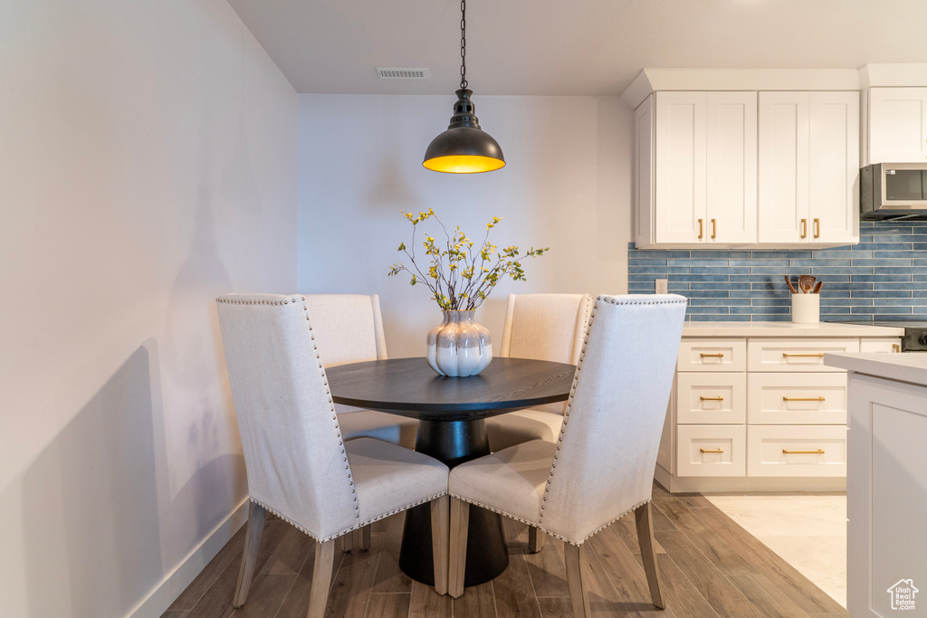 Dining area featuring baseboards, light wood-style flooring, and visible vents