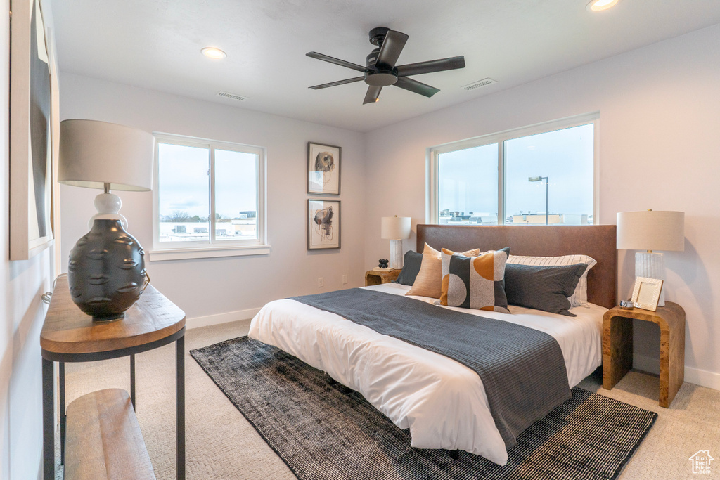 Bedroom featuring baseboards, light colored carpet, and visible vents