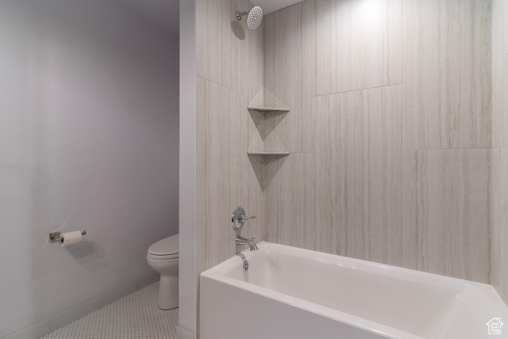 Full bathroom featuring baseboards,  shower combination, toilet, and tile patterned flooring