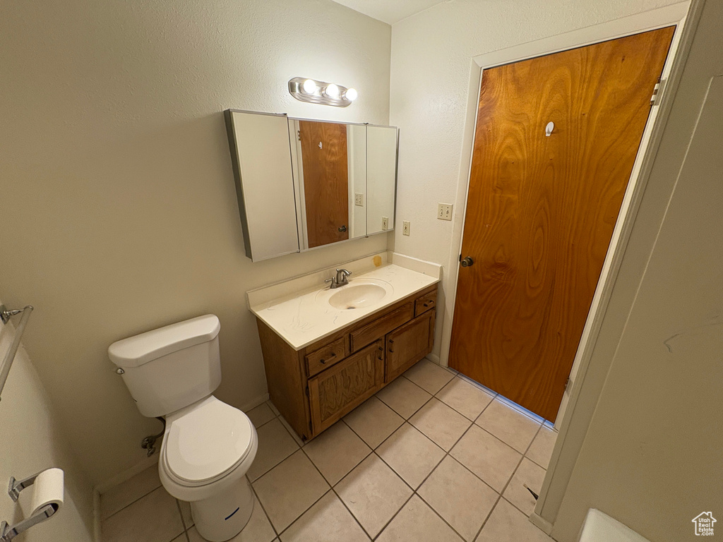 Bathroom with tile patterned flooring, vanity, and toilet