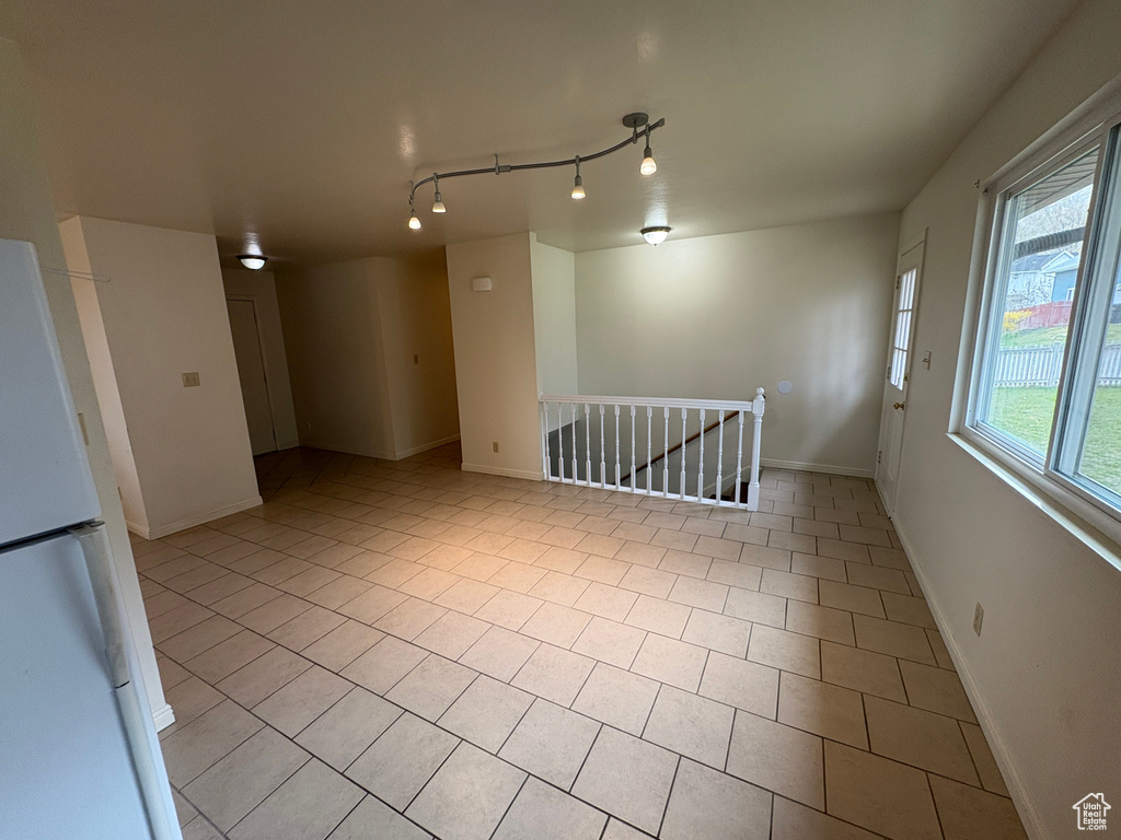 Spare room with baseboards and light tile patterned floors
