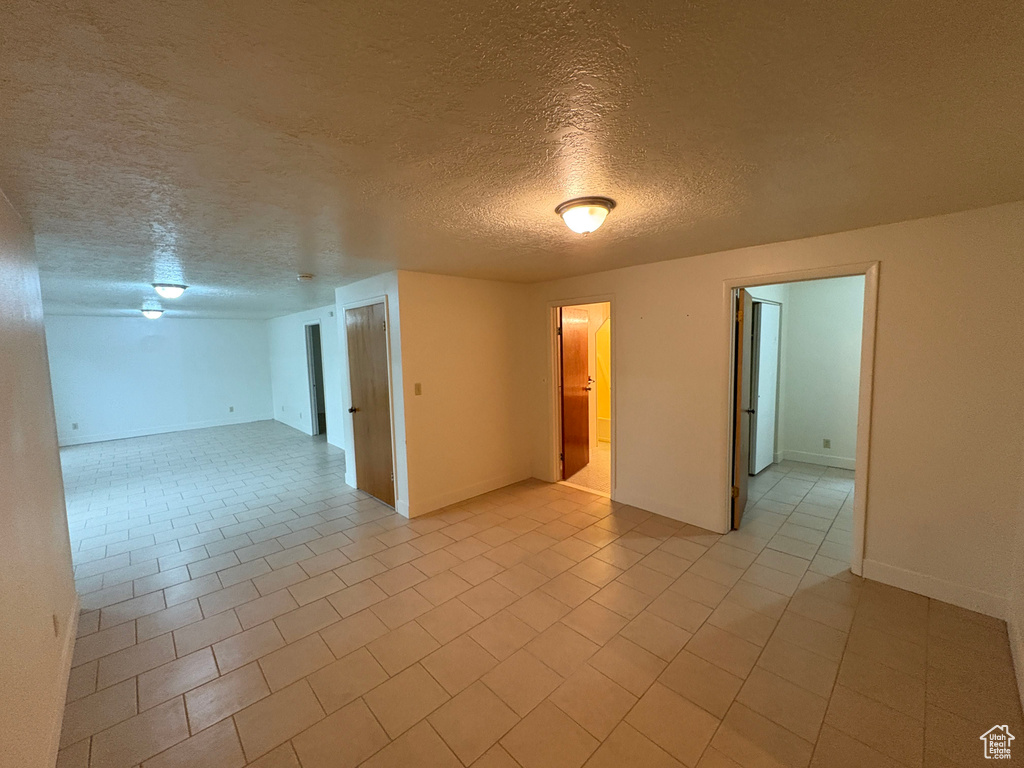 Spare room featuring baseboards and a textured ceiling