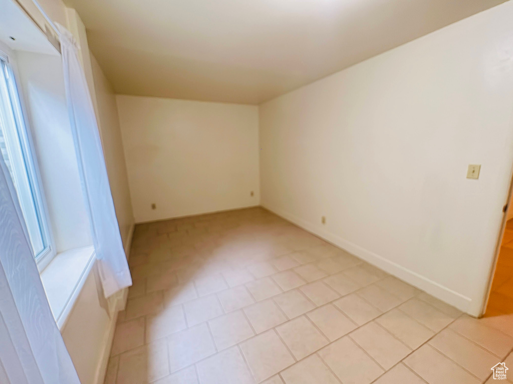 Spare room with baseboards and light tile patterned floors