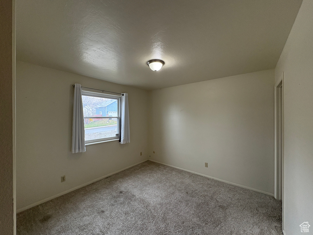 Spare room with baseboards and carpet