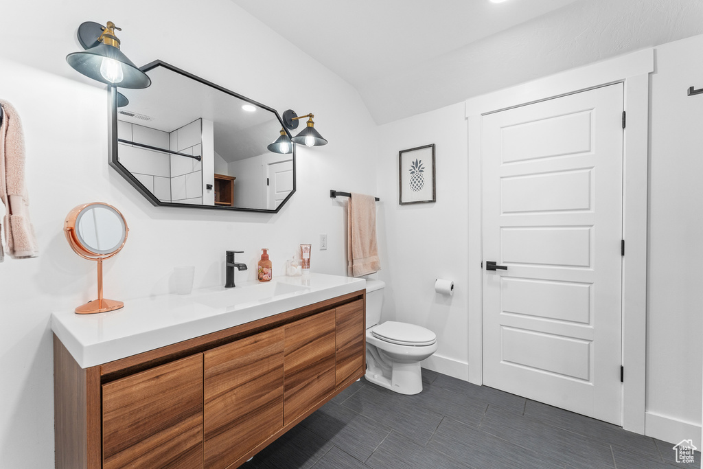 Bathroom featuring toilet, vanity, baseboards, and visible vents