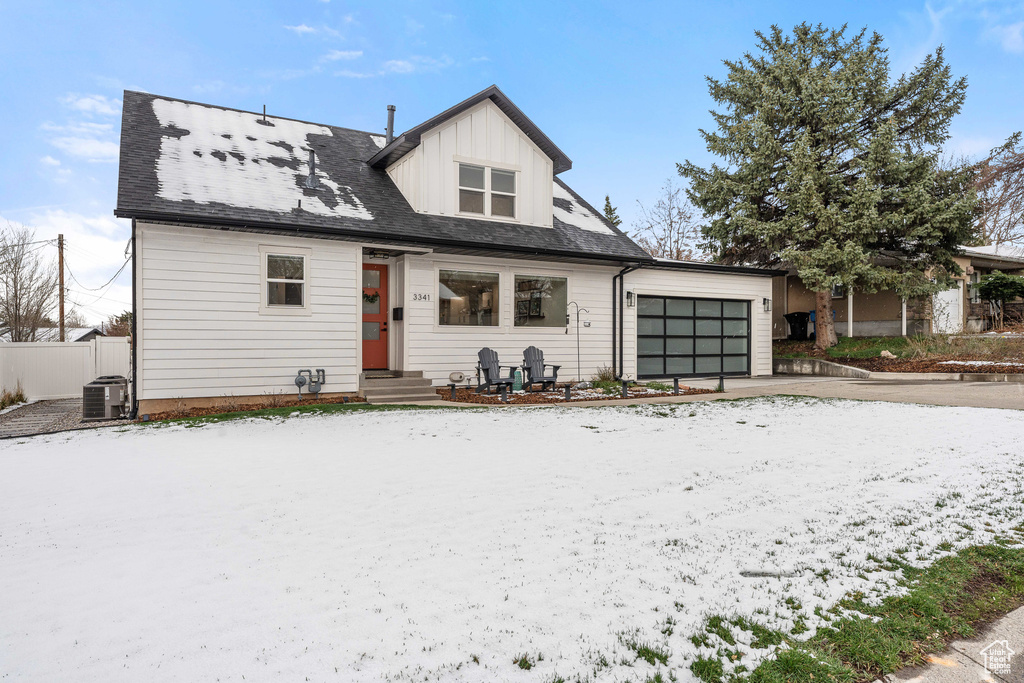 View of front of house with central air condition unit, an attached garage, fence, and driveway
