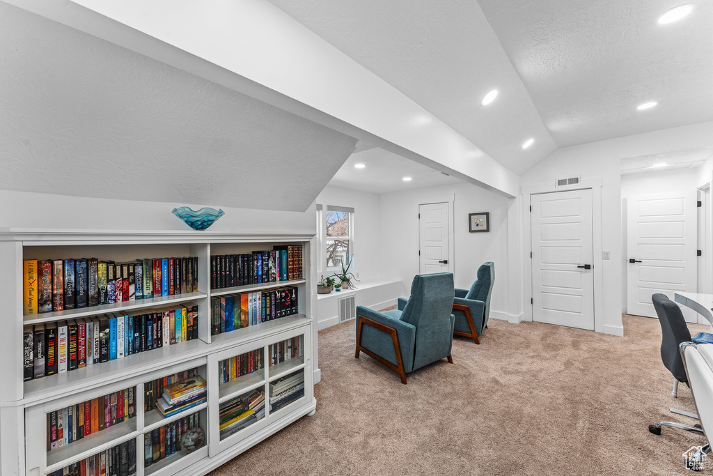 Carpeted home office featuring baseboards, vaulted ceiling, visible vents, and recessed lighting