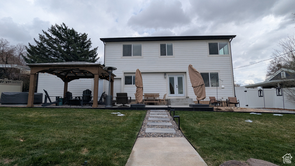 Rear view of house featuring fence, a patio, a gazebo, french doors, and a yard