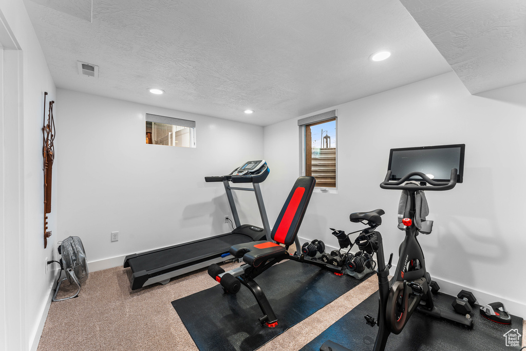 Exercise room featuring recessed lighting, carpet, baseboards, a textured ceiling, and visible vents