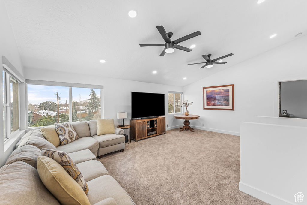 Carpeted living room with baseboards, vaulted ceiling, recessed lighting, and a ceiling fan