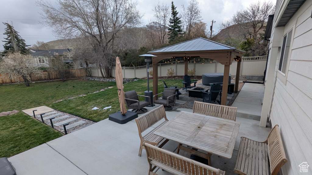 View of patio featuring a fenced backyard, a hot tub, a gazebo, and outdoor lounge area