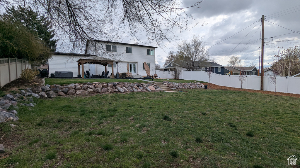 View of yard featuring a fenced backyard and a gazebo