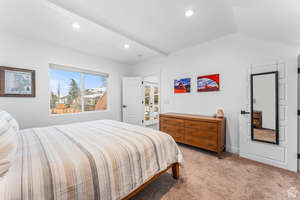 Bedroom with lofted ceiling, french doors, recessed lighting, and light carpet