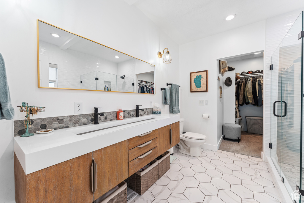 Full bathroom with tile patterned floors, a walk in closet, vanity, and a stall shower
