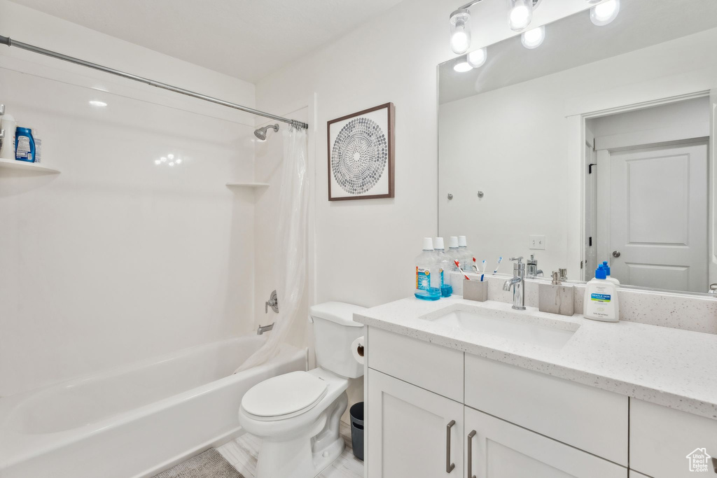 Full bath with toilet, shower / bath combo, and vanity