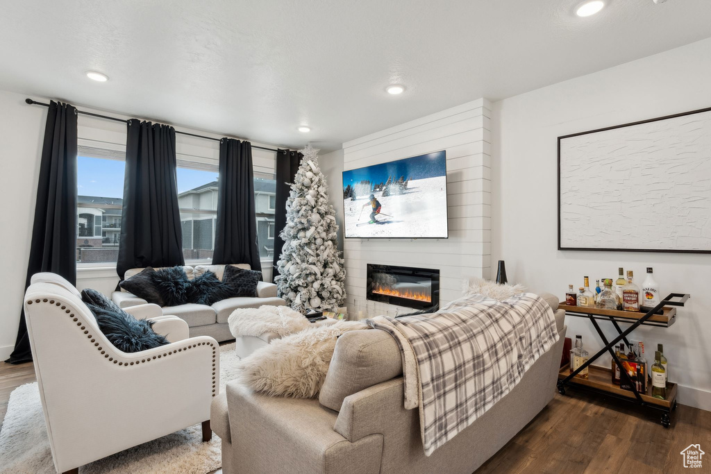 Living area with recessed lighting, a fireplace, and wood finished floors