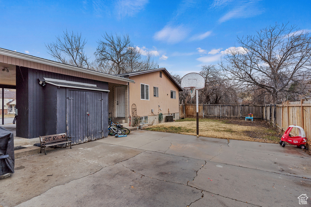 Rear view of property with a fenced backyard, a patio area, and a yard