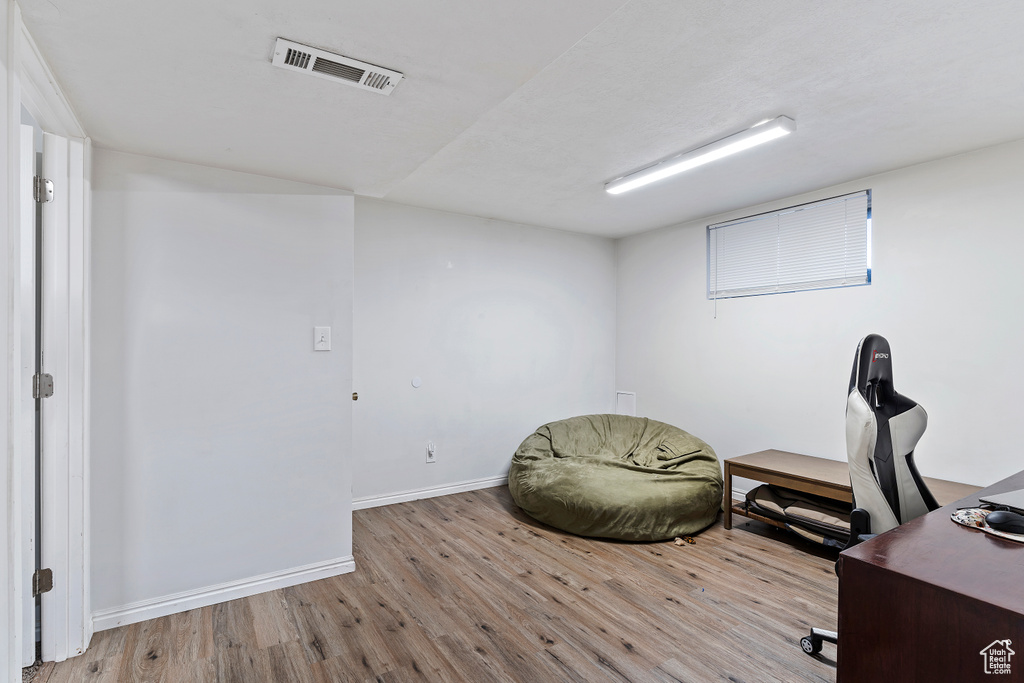 Office space with baseboards, light wood-style floors, and visible vents