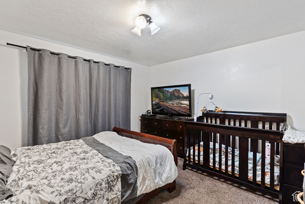 Carpeted bedroom featuring a textured ceiling