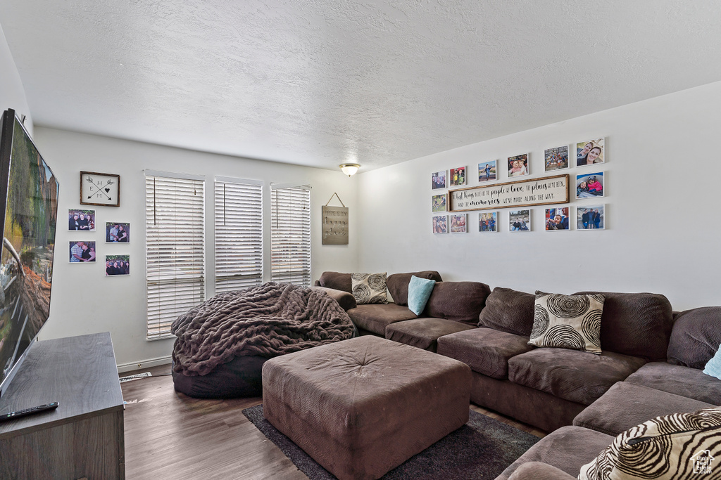 Living room with a textured ceiling and wood finished floors