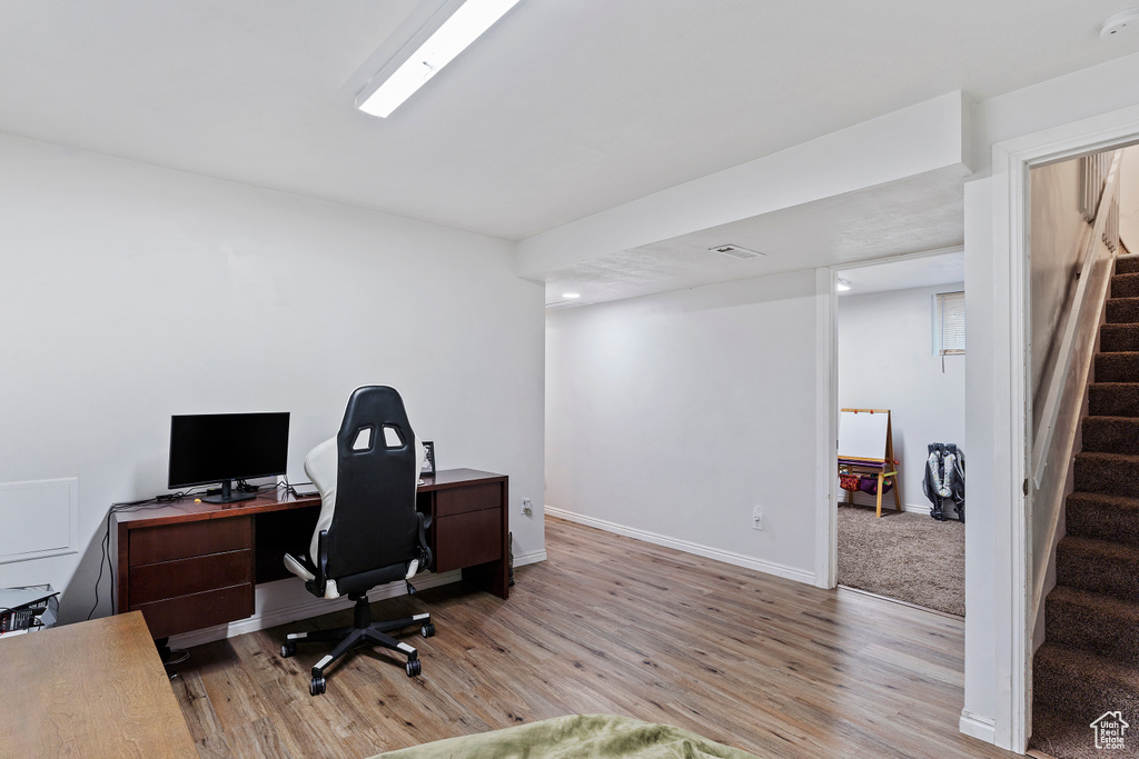 Office with baseboards, visible vents, and light wood finished floors