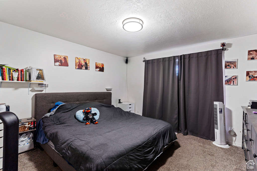 Bedroom with carpet floors and a textured ceiling