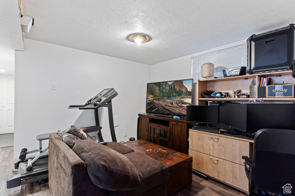 Interior space featuring a textured ceiling and dark wood-style flooring