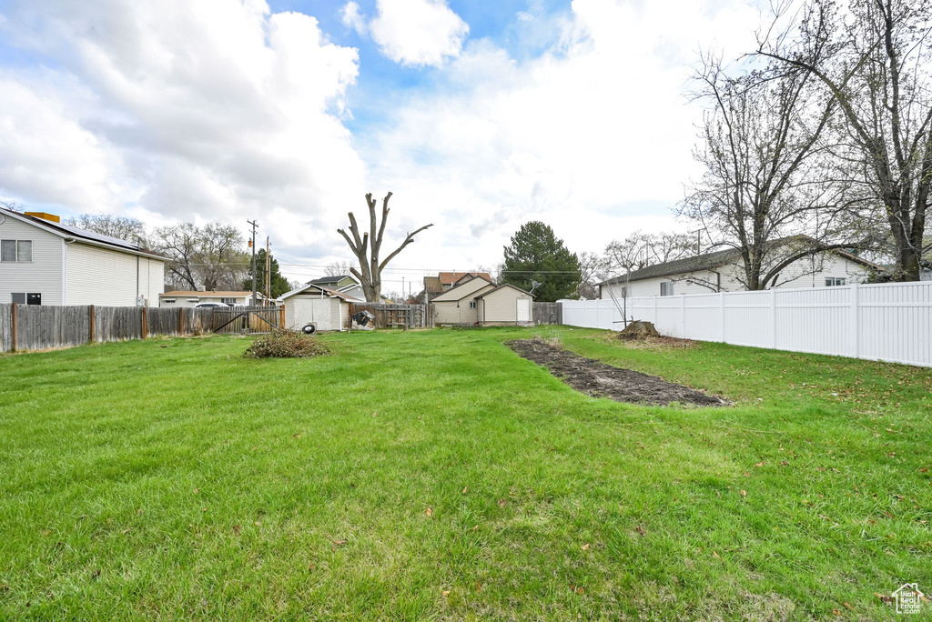 View of yard with a fenced backyard and an outdoor structure