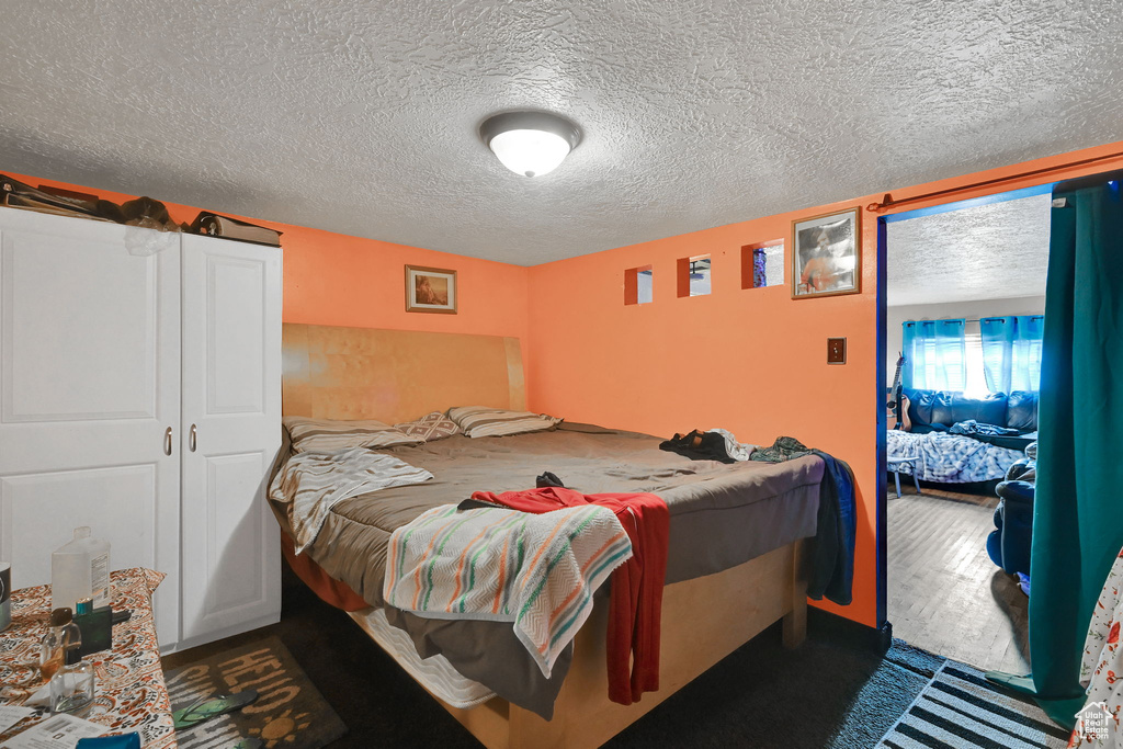 Bedroom featuring a textured ceiling and wood finished floors