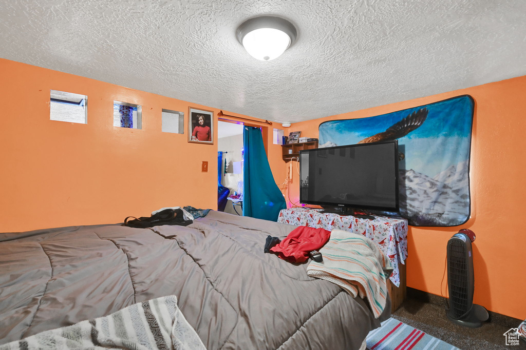 Carpeted bedroom with baseboards and a textured ceiling