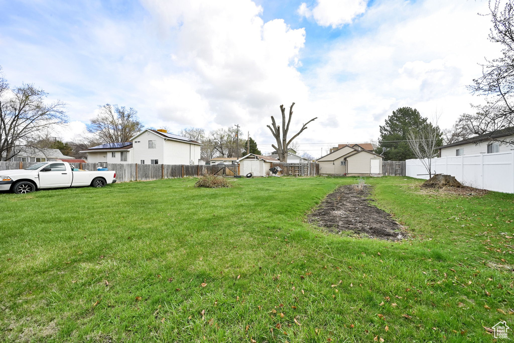 View of yard with an outbuilding, fence, and a storage shed