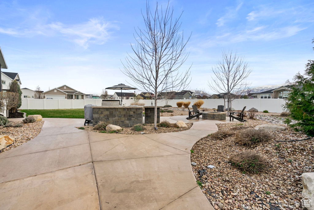 View of patio / terrace featuring a fenced backyard, a fire pit, and a residential view