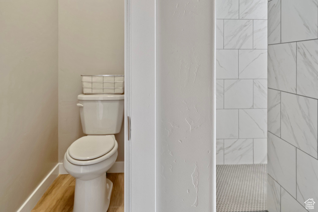 Bathroom with baseboards, toilet, and wood finished floors