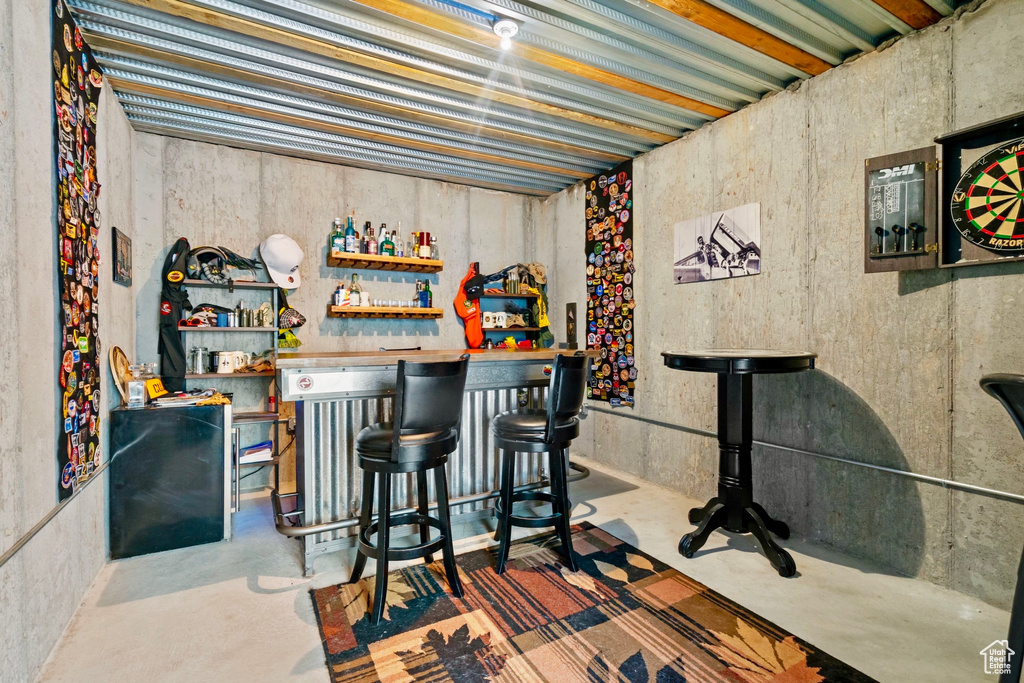 Bar featuring concrete floors and a dry bar