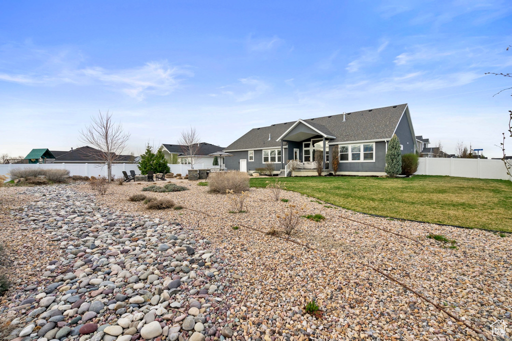 Back of house with a lawn and fence