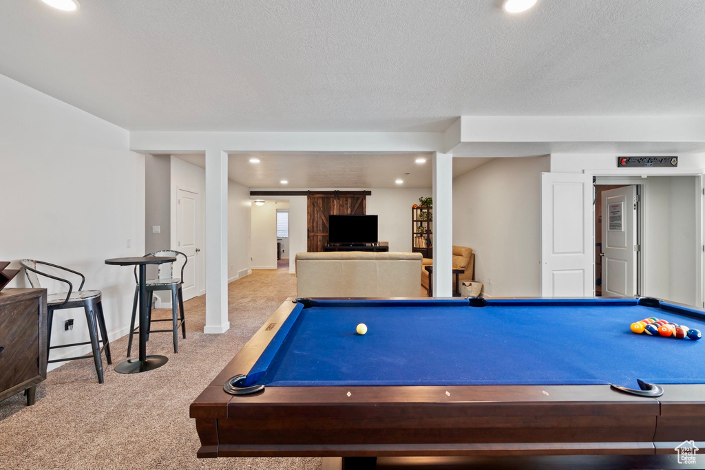 Recreation room with a textured ceiling, recessed lighting, a barn door, billiards, and carpet floors
