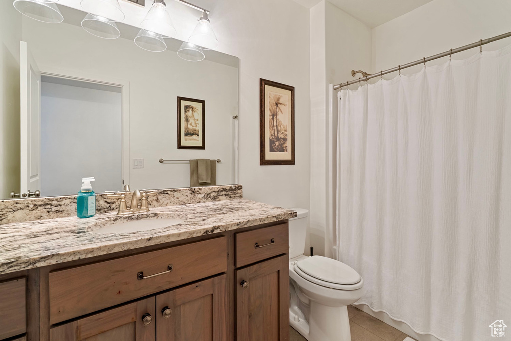 Bathroom featuring a shower with shower curtain, toilet, tile patterned flooring, and vanity