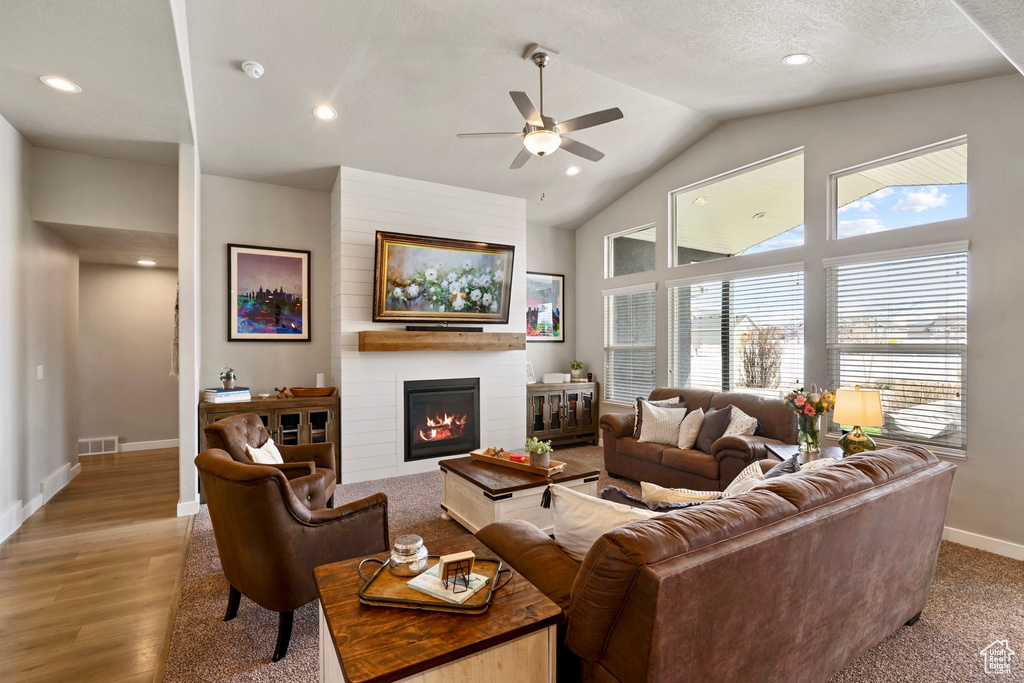 Living room with visible vents, baseboards, a fireplace, ceiling fan, and wood finished floors
