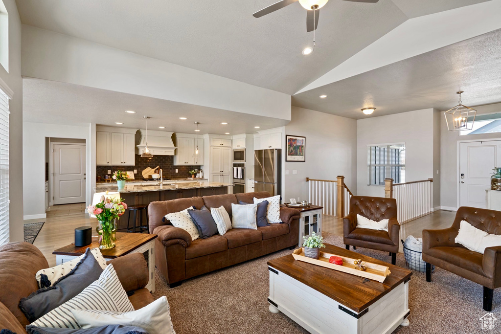 Living area with recessed lighting, high vaulted ceiling, baseboards, and ceiling fan