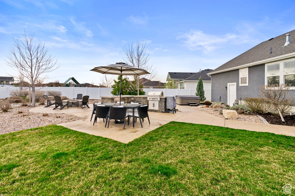 View of yard with a hot tub, a fenced backyard, and a patio
