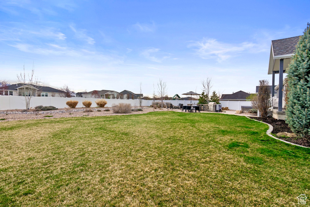 View of yard with a fenced backyard, a residential view, and a patio